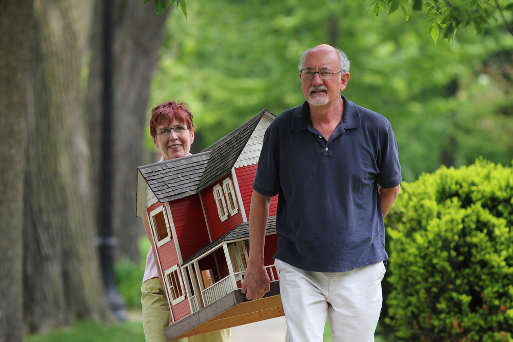 man and woman carry a large miniature at home